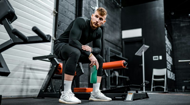 woman in black long sleeve shirt and black pants sitting on exercise equipment